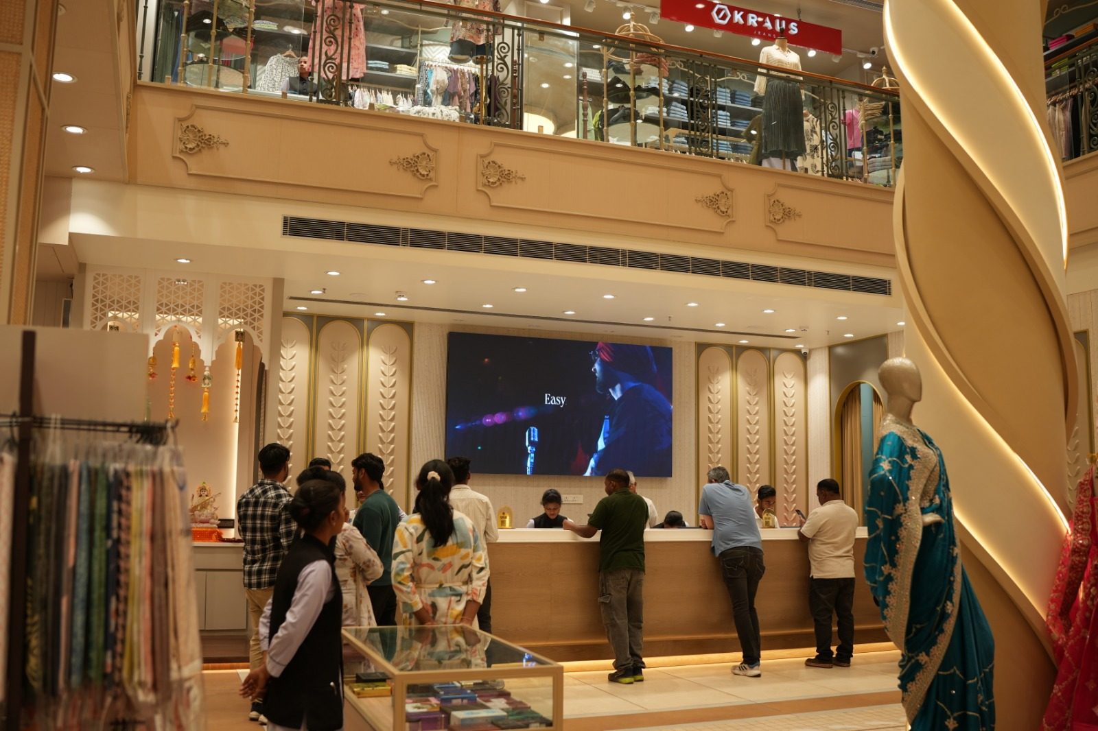 Interior of Punjab Cloth Store showing the ground-floor counter, mannequins in bridal wear, and the mezzanine menswear floor above
