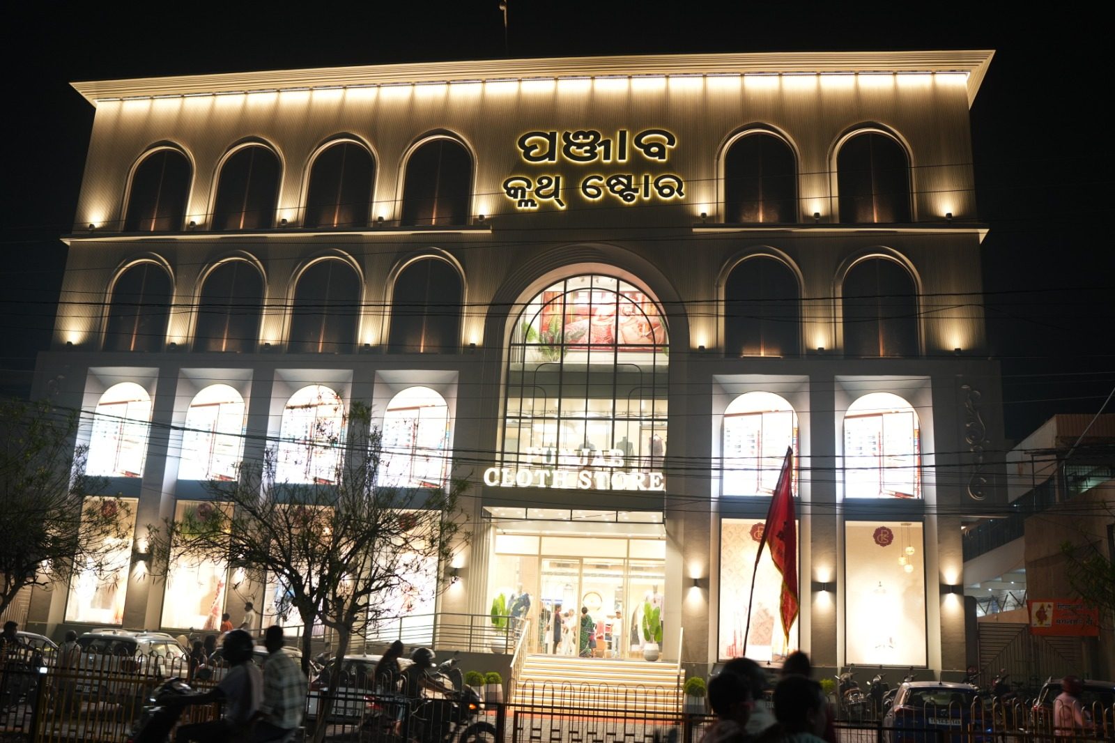 Punjab Cloth Store, a four-storey illuminated showroom building at night, Jharsuguda